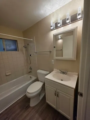 a bathroom with a toilet sink vanity and mirror