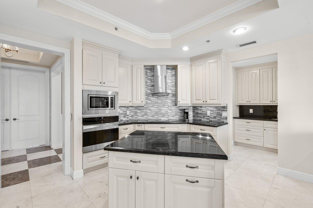 3000 Florida A1A, Unit 302 Daytona Beach, FL 32118 - Photo 11 of 48 a kitchen with granite countertop white cabinets and white appliances