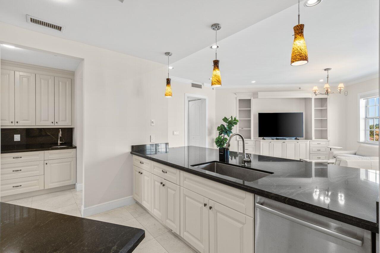 3000 Florida A1A, Unit 302 Daytona Beach, FL 32118 - Photo 13 of 48 a kitchen with granite countertop a sink and a stove top oven