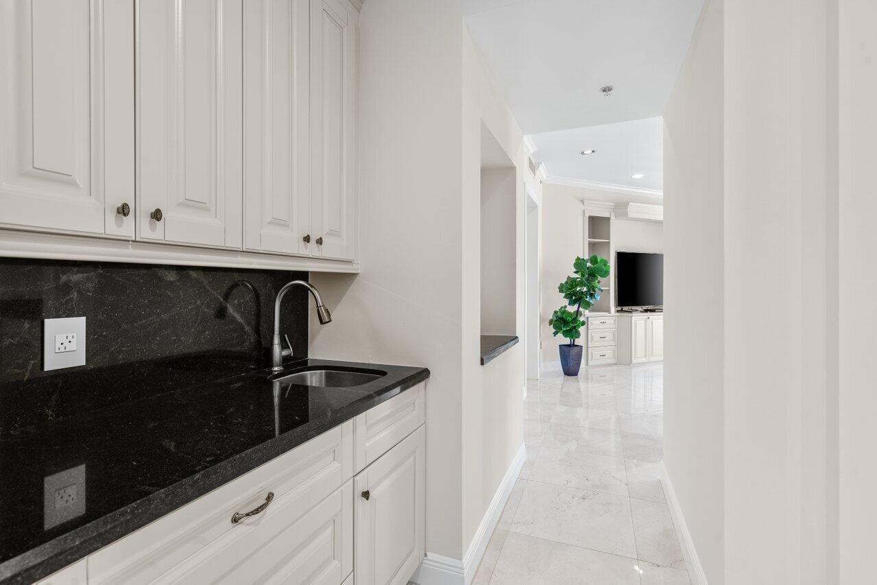 3000 Florida A1A, Unit 302 Daytona Beach, FL 32118 - Photo 14 of 48 a kitchen with granite countertop white cabinets and black appliances