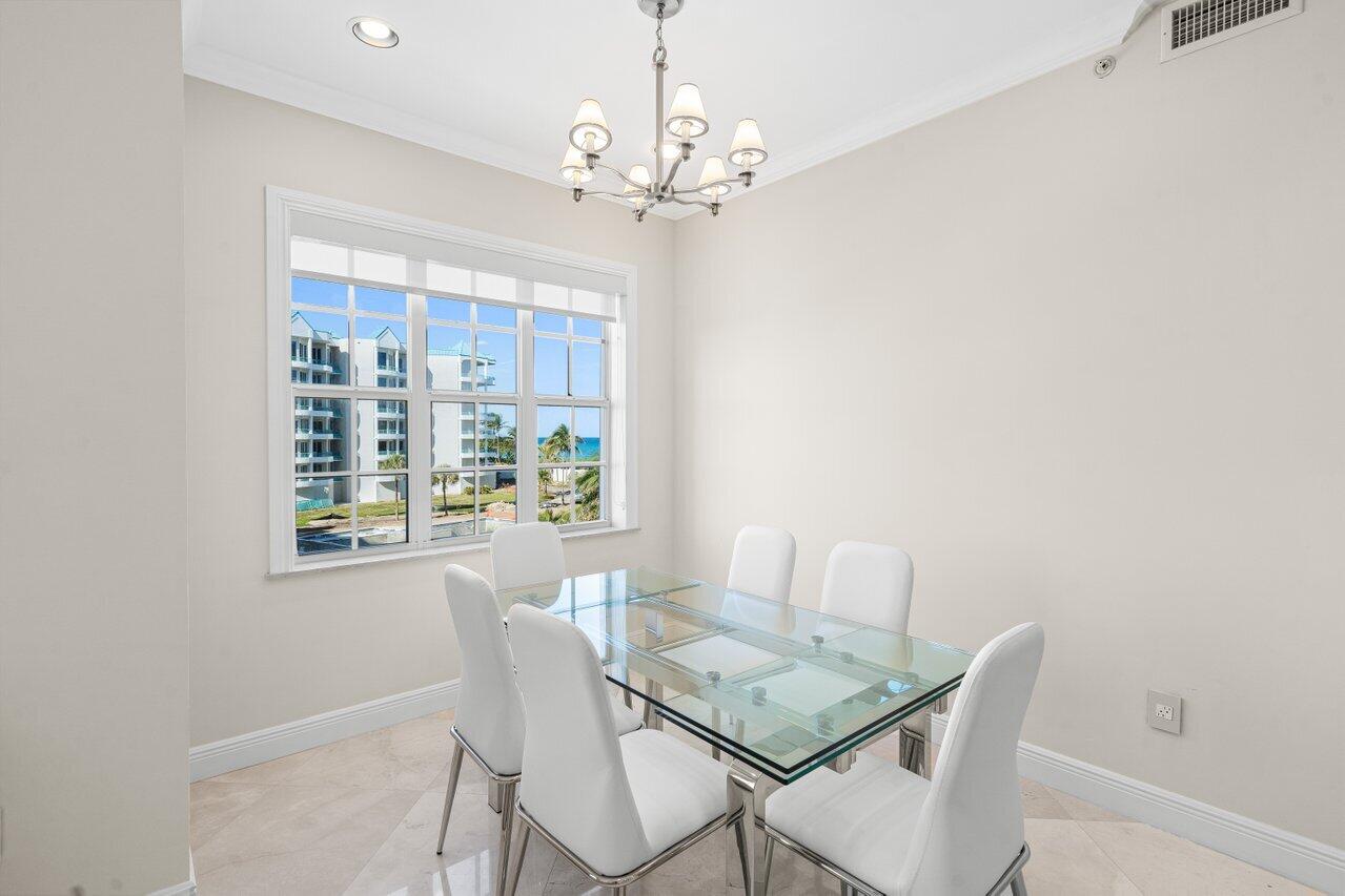3000 Florida A1A, Unit 302 Daytona Beach, FL 32118 - Photo 17 of 48 a view of a dining room with furniture a chandelier and wooden floor