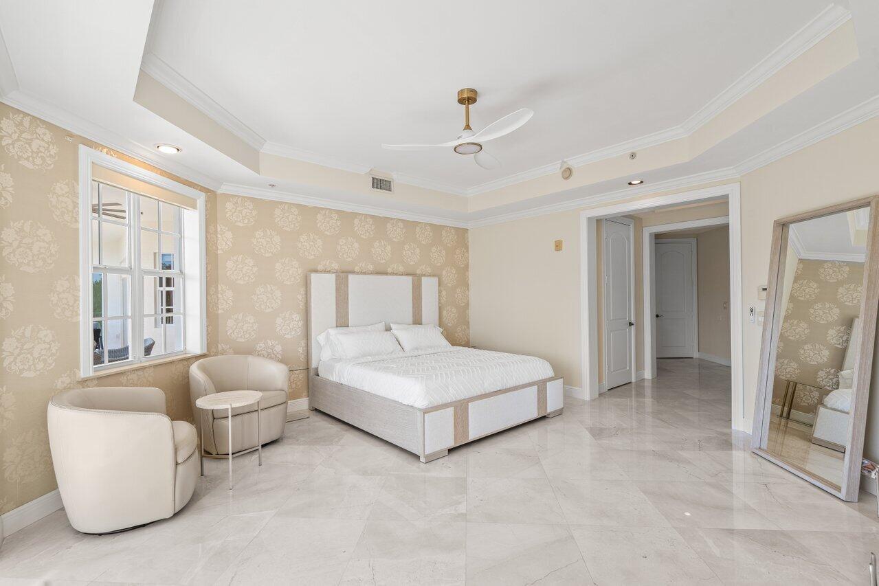 3000 Florida A1A, Unit 302 Daytona Beach, FL 32118 - Photo 23 of 48 a spacious bedroom with a bed and a chandelier