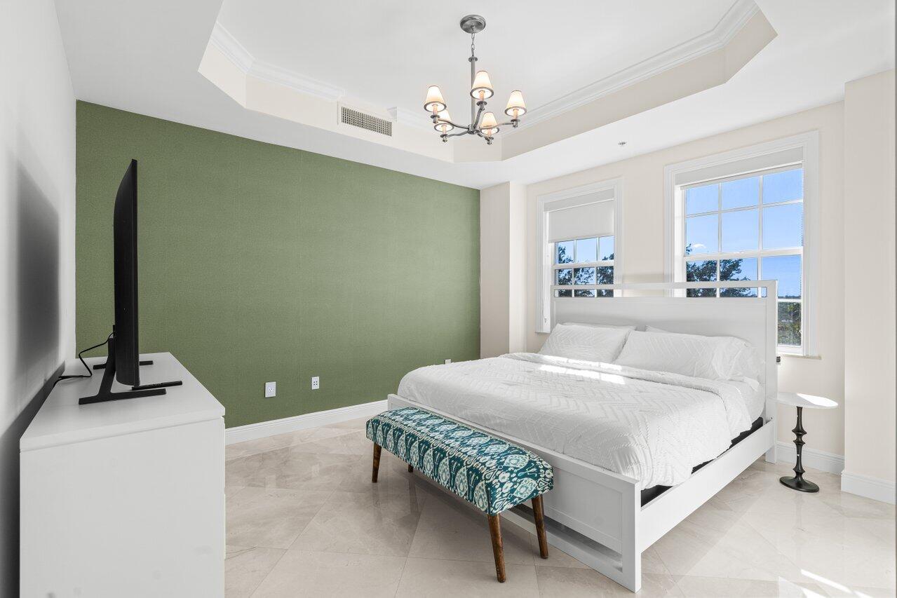 3000 Florida A1A, Unit 302 Daytona Beach, FL 32118 - Photo 27 of 48 a bedroom with a bed and a chandelier