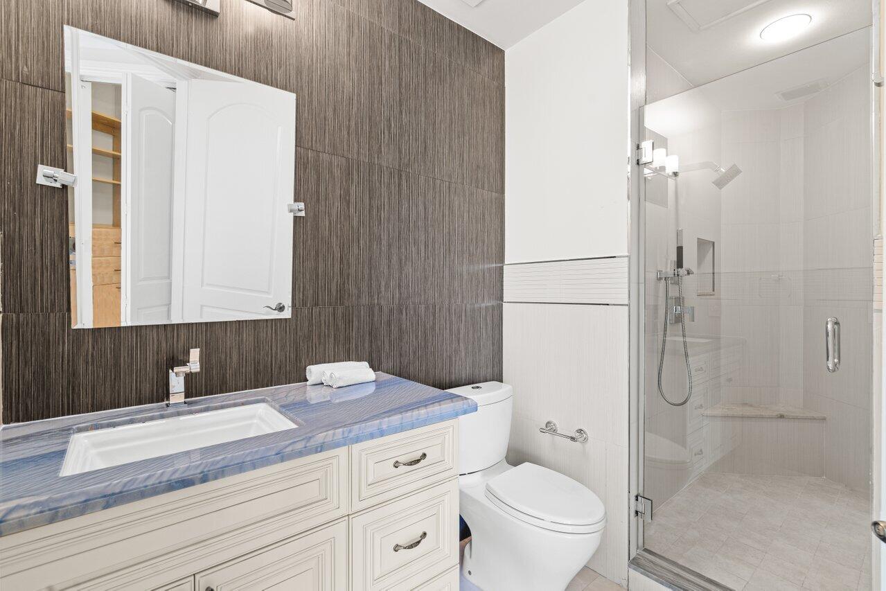 3000 Florida A1A, Unit 302 Daytona Beach, FL 32118 - Photo 28 of 48 a bathroom with a granite countertop sink a toilet and shower