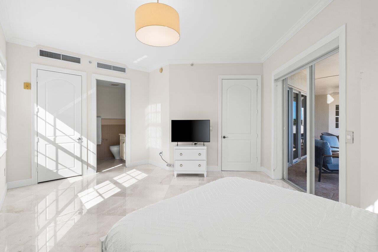 3000 Florida A1A, Unit 302 Daytona Beach, FL 32118 - Photo 29 of 48 a bedroom with a bed and a flat tv screen next to a window