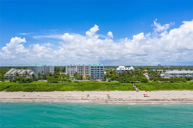 a front view of multi story residential apartment building with yard and green space