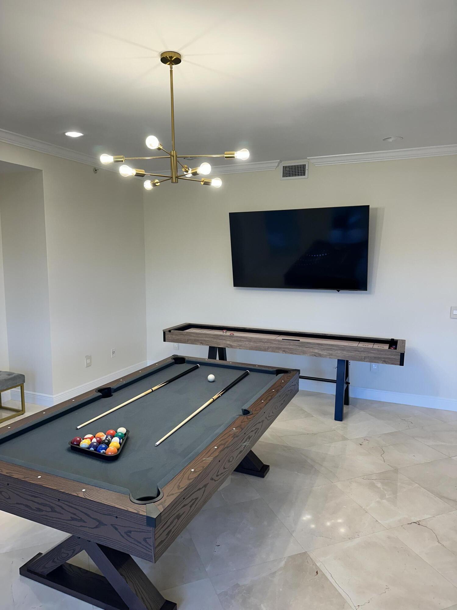3000 Florida A1A, Unit 302 Daytona Beach, FL 32118 - Photo 47 of 48 a living room with furniture pool table and a flat screen tv
