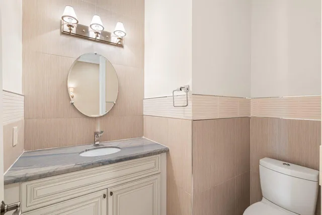 a bathroom with a toilet a sink and mirror