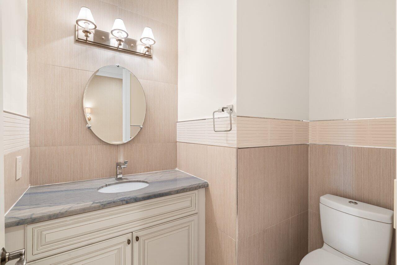 3000 Florida A1A, Unit 302 Daytona Beach, FL 32118 - Photo 9 of 48 a bathroom with a toilet a sink and mirror