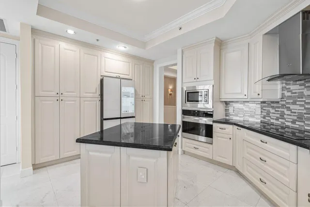 a kitchen with granite countertop white cabinets and stainless steel appliances