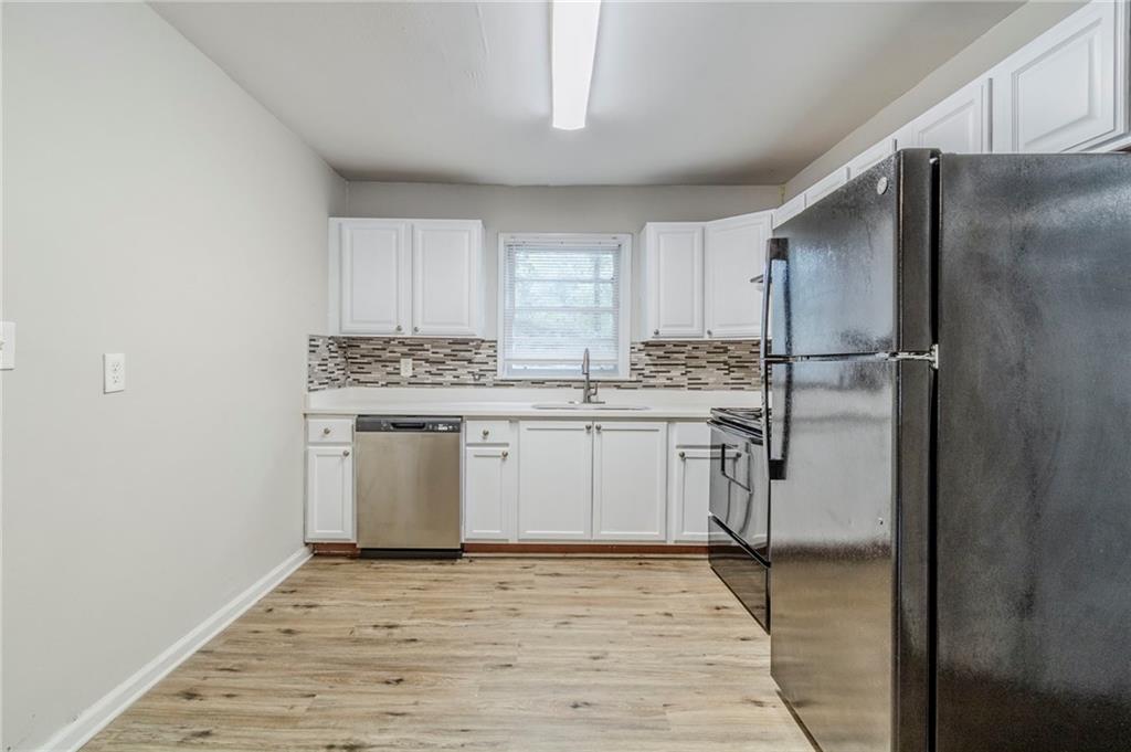 6281 Denny Lane Southwest Mableton, GA 30126 - Photo 11 of 27 a kitchen with a sink stainless steel appliances and white cabinets
