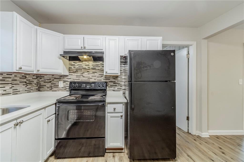 6281 Denny Lane Southwest Mableton, GA 30126 - Photo 12 of 27 a kitchen with stainless steel appliances granite countertop a refrigerator and a stove top oven