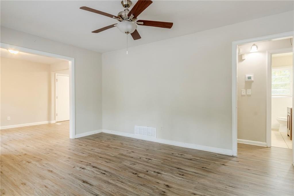 6281 Denny Lane Southwest Mableton, GA 30126 - Photo 8 of 27 an empty room with wooden floor a ceiling fan and windows