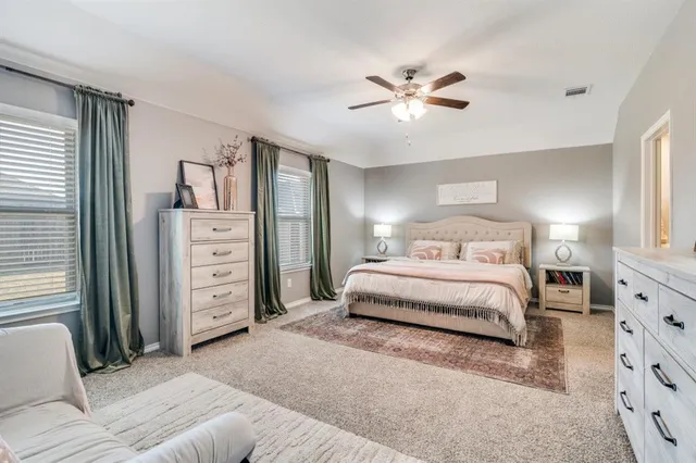 a spacious bedroom with a bed and a chandelier