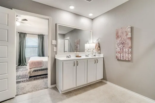 a en suite bathroom with a double vanity sink and a mirror