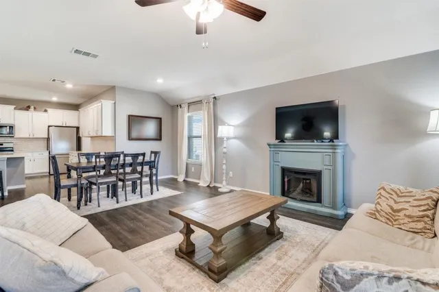 a living room with furniture a fireplace and a flat screen tv