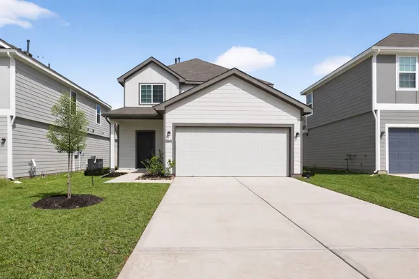 a front view of a house with a yard and garage
