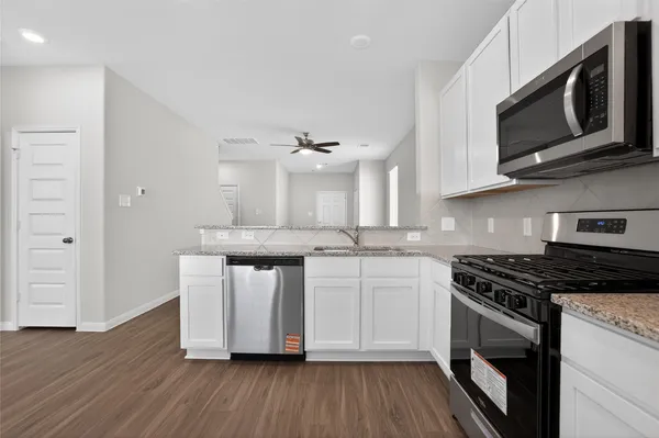 a kitchen with stainless steel appliances granite countertop a stove a microwave and cabinets