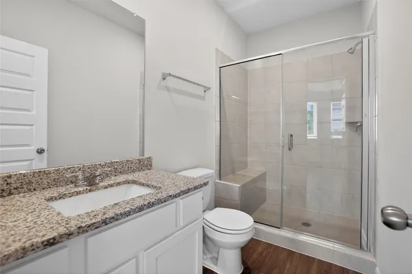 a bathroom with a granite countertop sink toilet and shower