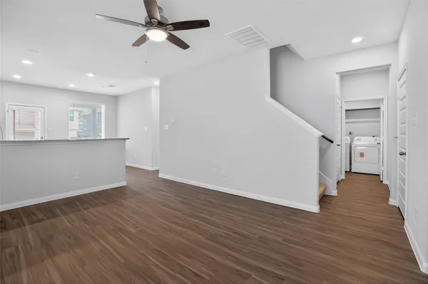a view of a kitchen with wooden floor and a ceiling fan