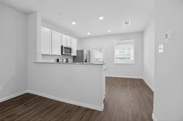 a view of kitchen with wooden floor and electronic appliances