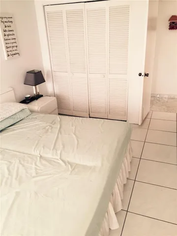 a bedroom with a bed and a large mirror