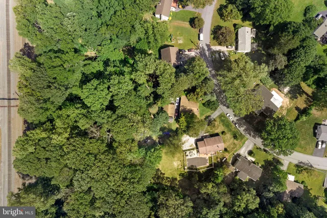 an aerial view of residential house with outdoor space and trees all around