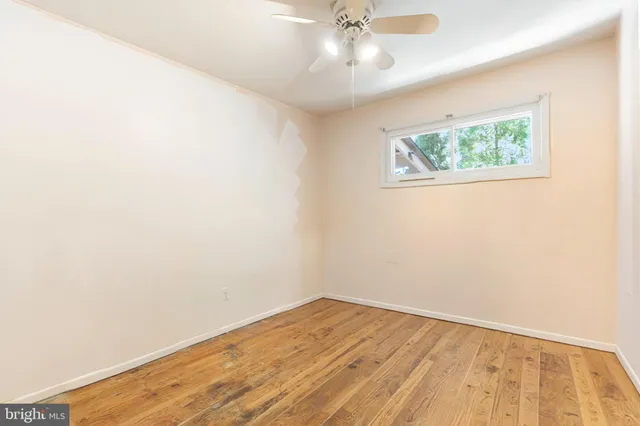an empty room with a window and wooden floor