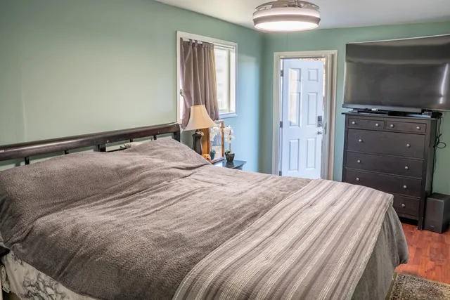 a bedroom with a bed and flat screen tv