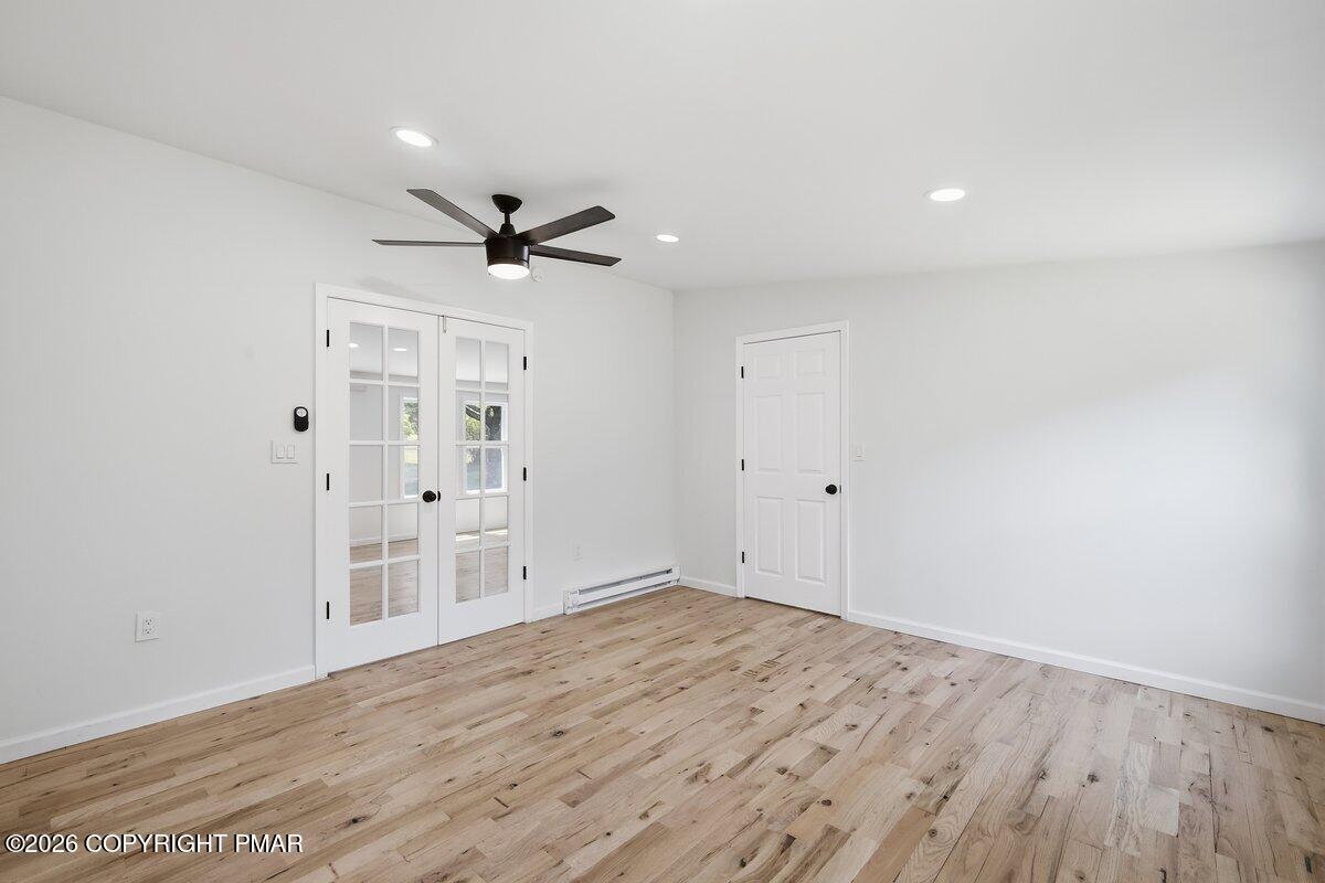 155 Blooming Grove Road Hawley, PA 18428 - Photo 32 of 41 wooden floor in an empty room with a ceiling fan