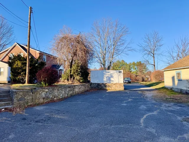a view of a house with large tree and wooden fence