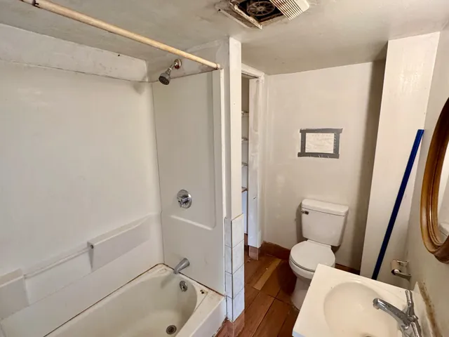 a bathroom with a tub and a toilet