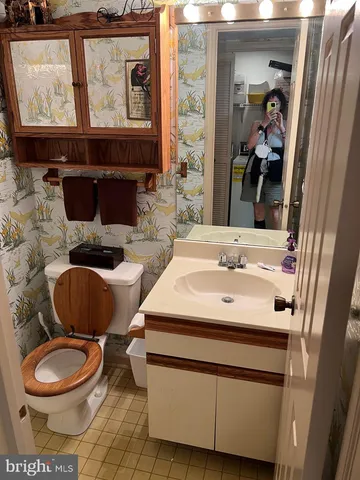 a bathroom with a toilet a sink and a mirror