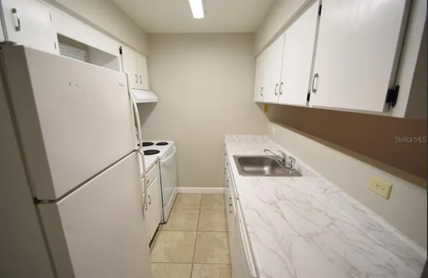 a kitchen with a refrigerator and a stove