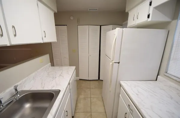 a kitchen with a refrigerator sink and cabinets