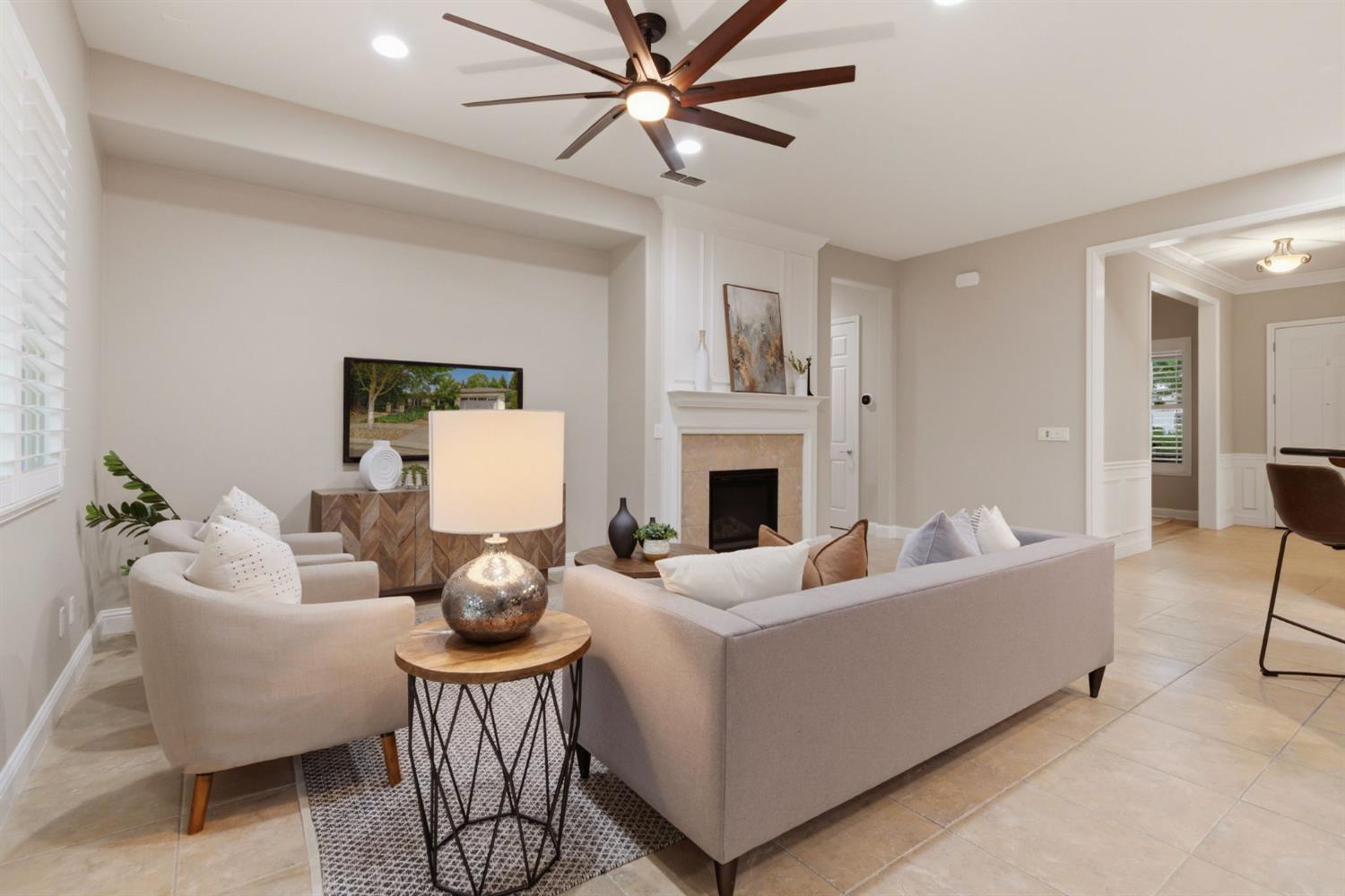 2499 Appleleaf Lane Manteca, CA 95336 - Photo 17 of 55 a living room with furniture a fireplace and a chandelier