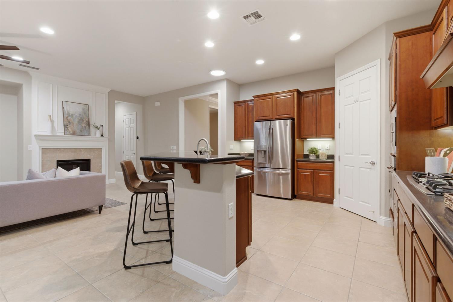 2499 Appleleaf Lane Manteca, CA 95336 - Photo 27 of 55 a kitchen with a refrigerator a stove microwave oven with a dining table and chairs
