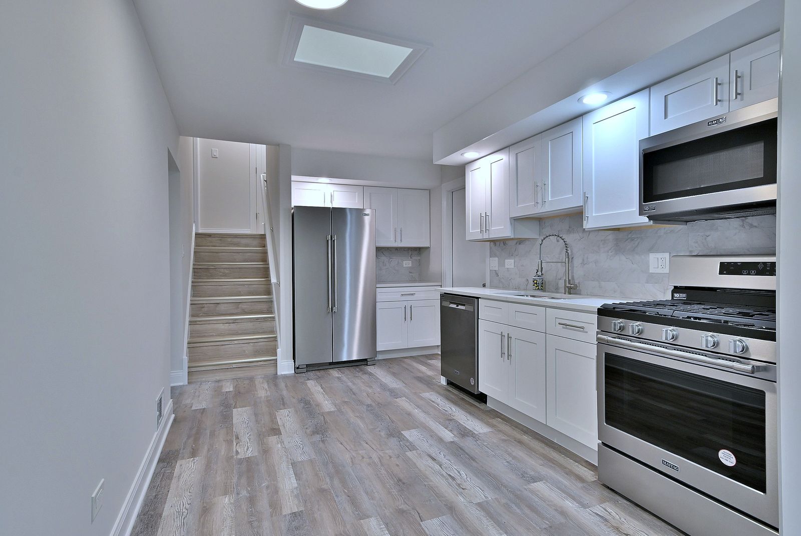 15262 74th Avenue, Unit 36 Orland Park, IL 60462 - Photo 10 of 25 a kitchen with stainless steel appliances a stove a microwave and cabinets