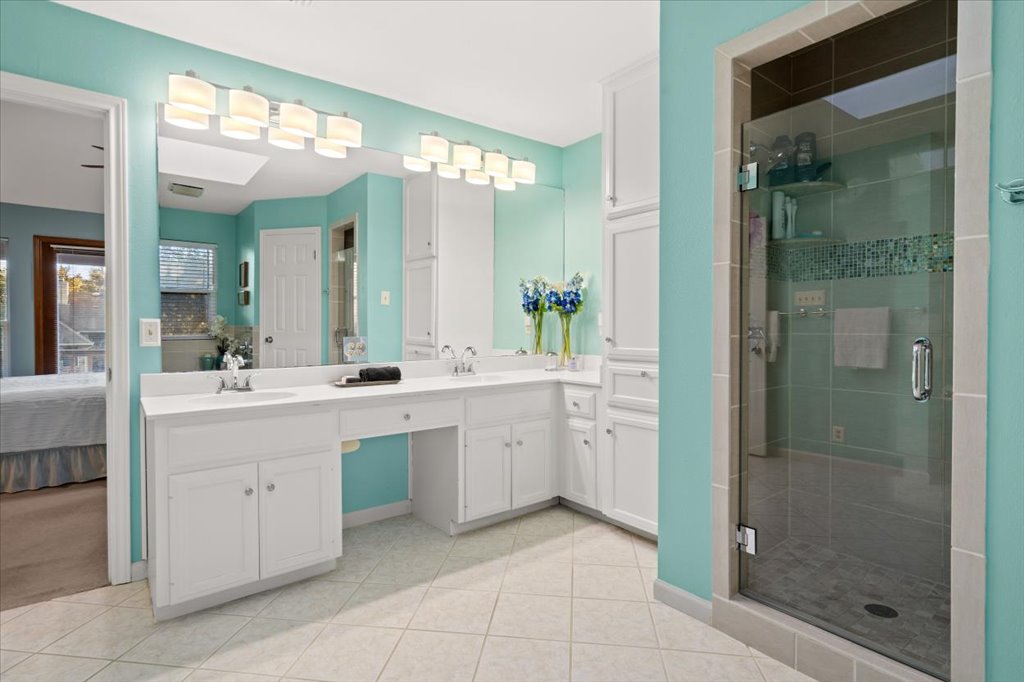 3803 Frodo Cove Austin, TX 78739 - Photo 22 of 40 a spacious bathroom with a shower sink and mirror