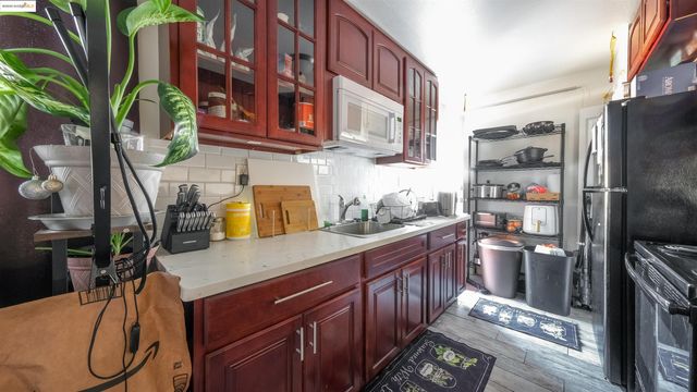 a kitchen with stainless steel appliances granite countertop a refrigerator a stove and a wooden floors