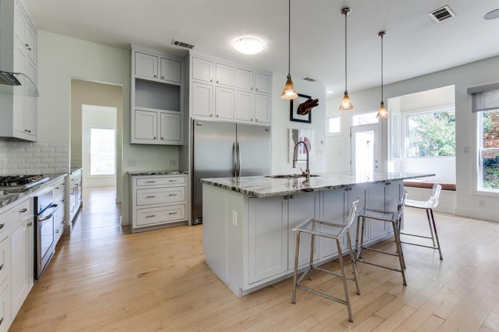 4206 Manning Lane Dallas, TX 75220 - Photo 14 of 35 a kitchen with stainless steel appliances kitchen island a table chairs in it and wooden floors
