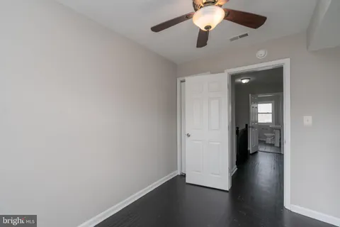 an empty room with a window and a ceiling fan