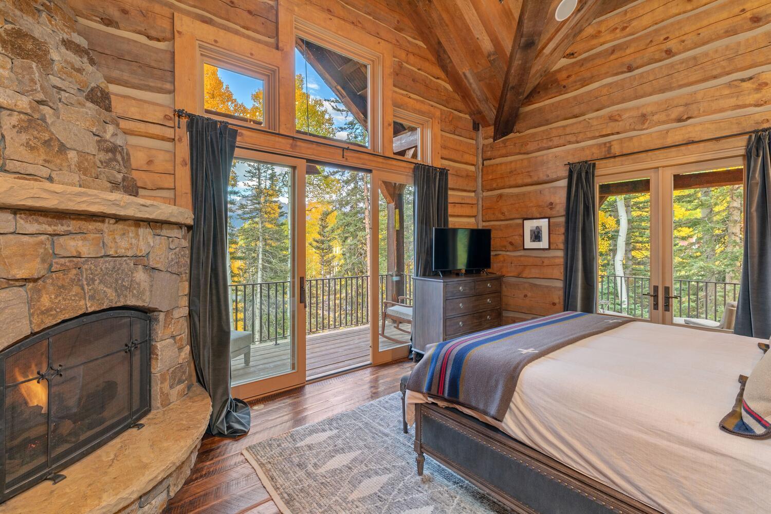 274 Benchmark Drive Mountain Village, CO 81435 - Photo 32 of 58 a spacious bedroom with a bed and a fireplace