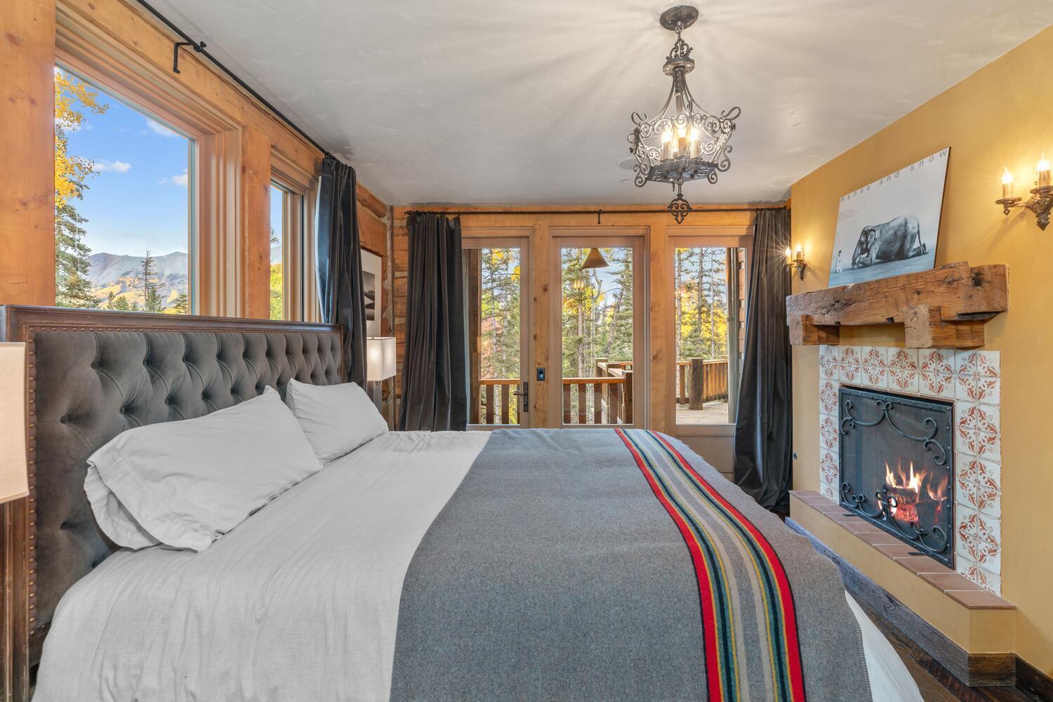 274 Benchmark Drive Mountain Village, CO 81435 - Photo 48 of 58 a spacious bedroom with a balcony a bed and a fireplace