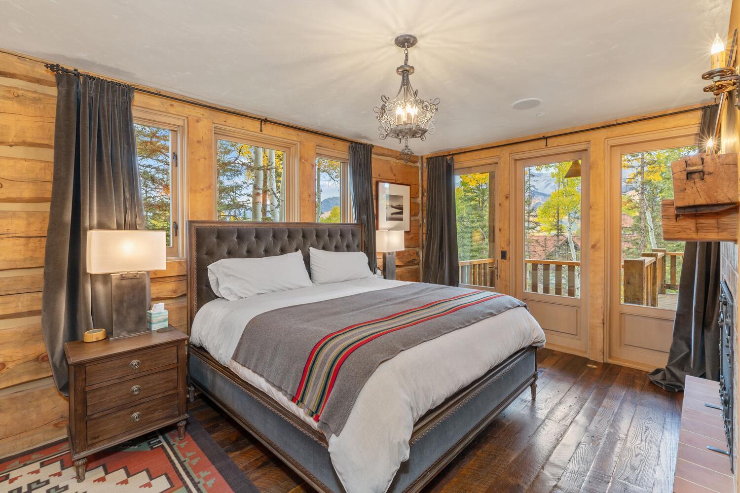 274 Benchmark Drive Mountain Village, CO 81435 - Photo 49 of 58 a bedroom with a large bed and a chandelier