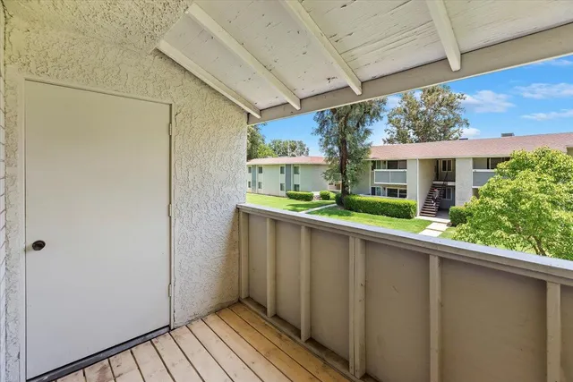a view of a balcony with wooden floor and plants