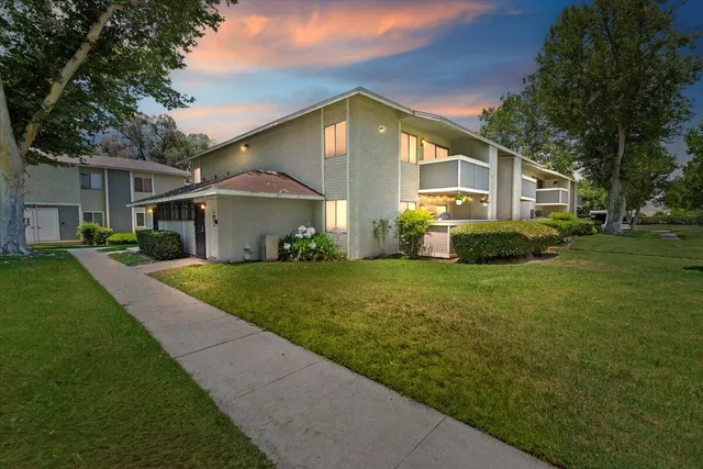 a front view of a house with a yard and trees
