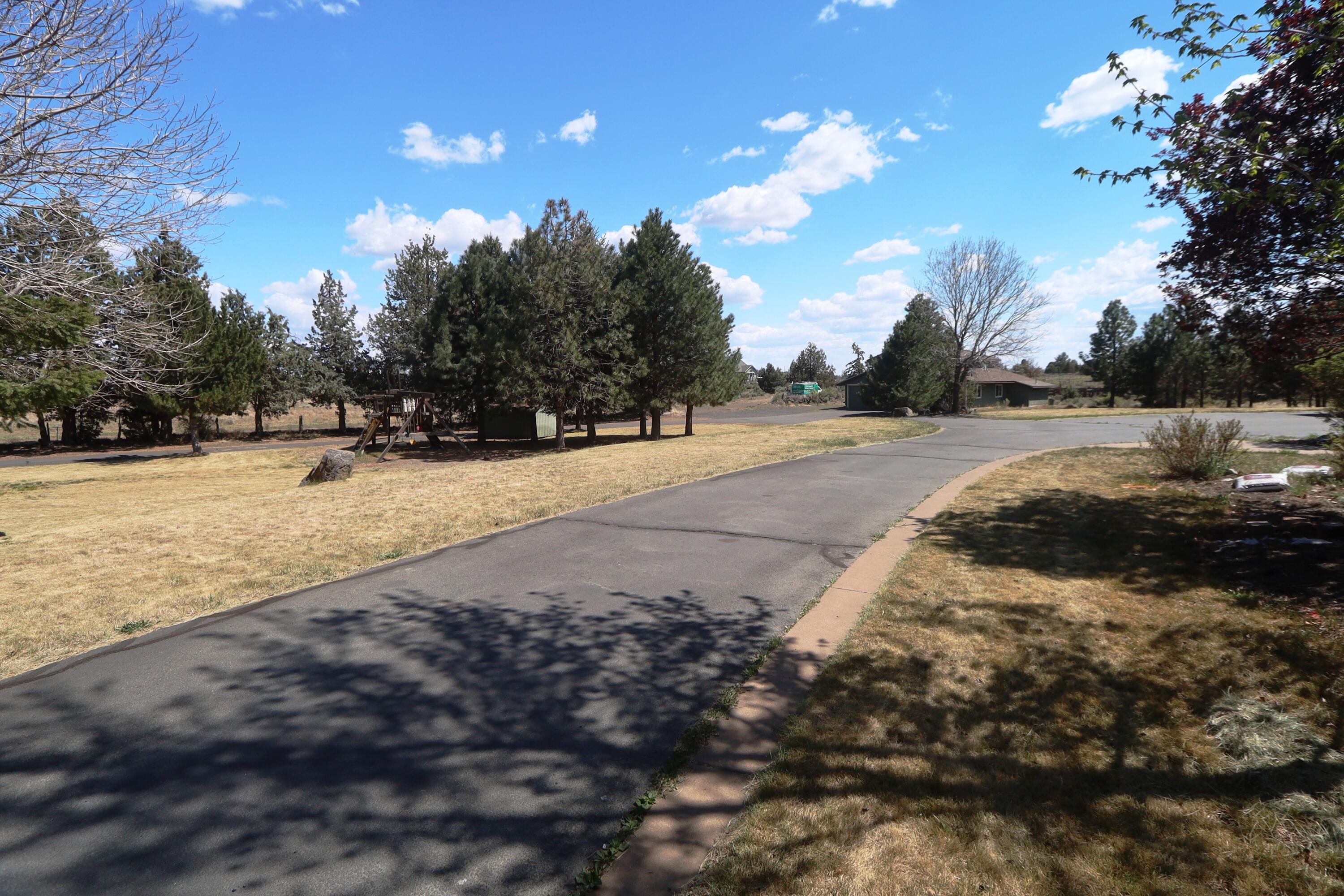 21491 Bear Creek Road Bend, OR 97701 - Photo 2 of 45 a view of dirt yard with a large tree