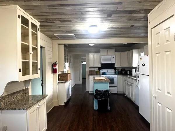 a kitchen with granite countertop a stove and cabinets