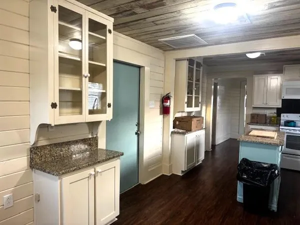 a kitchen with granite countertop a stove a sink and a microwave